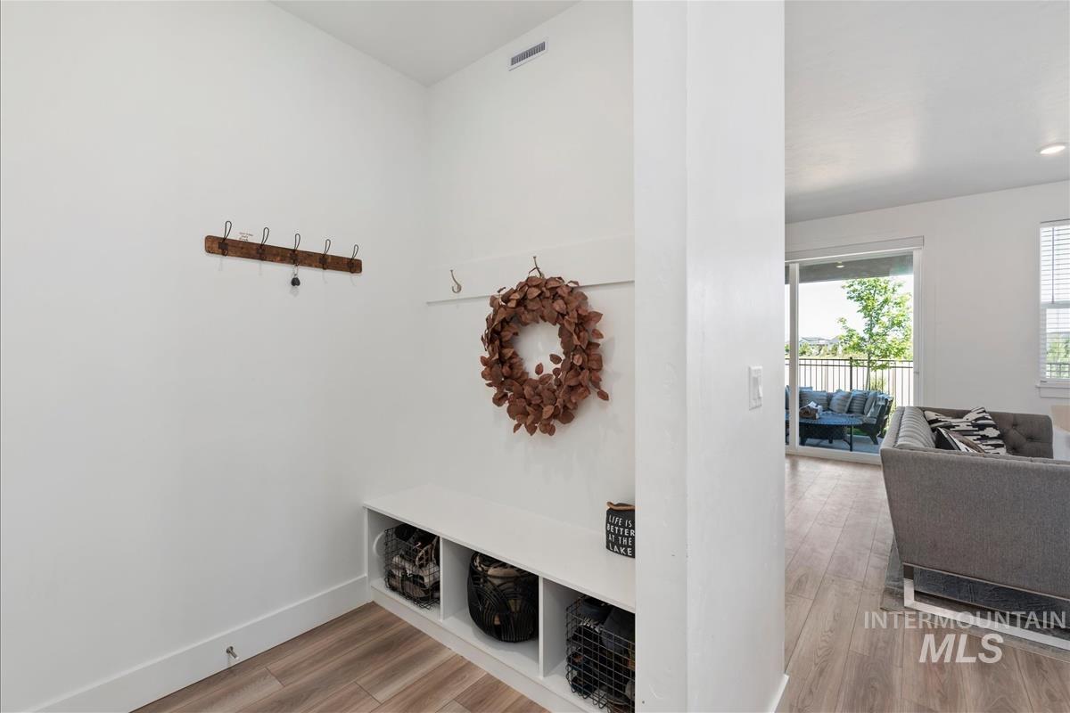 Entryway with integrated bench and storage cubbies, wood-finish flooring, and white walls