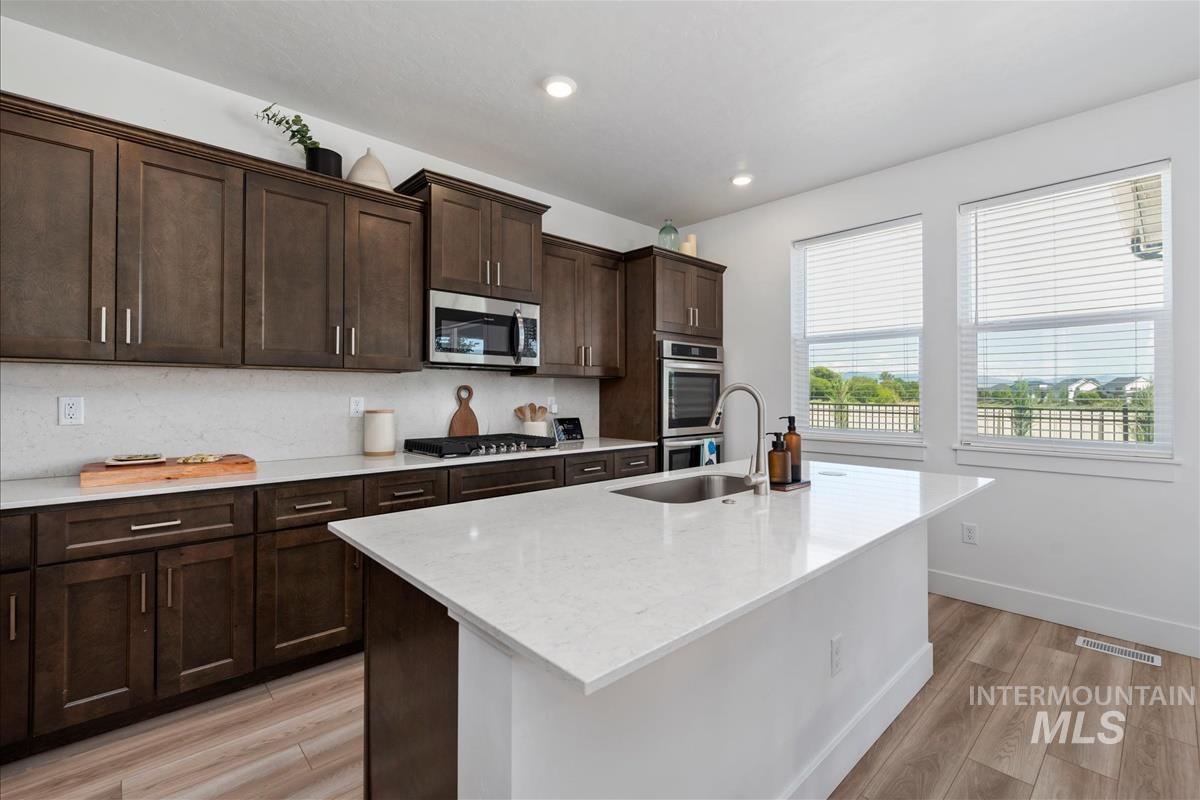 Modern kitchen featuring dark wood cabinetry and light-toned countertops