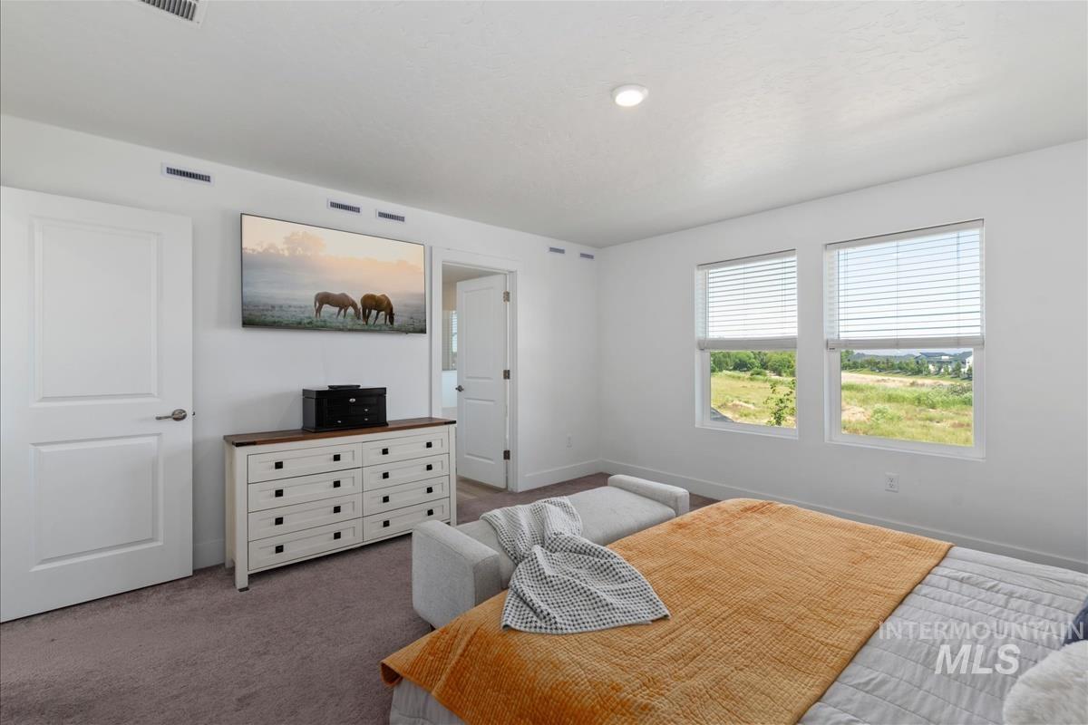 Bedroom with two windows providing natural light, white interior doors, and recessed ceiling lighting