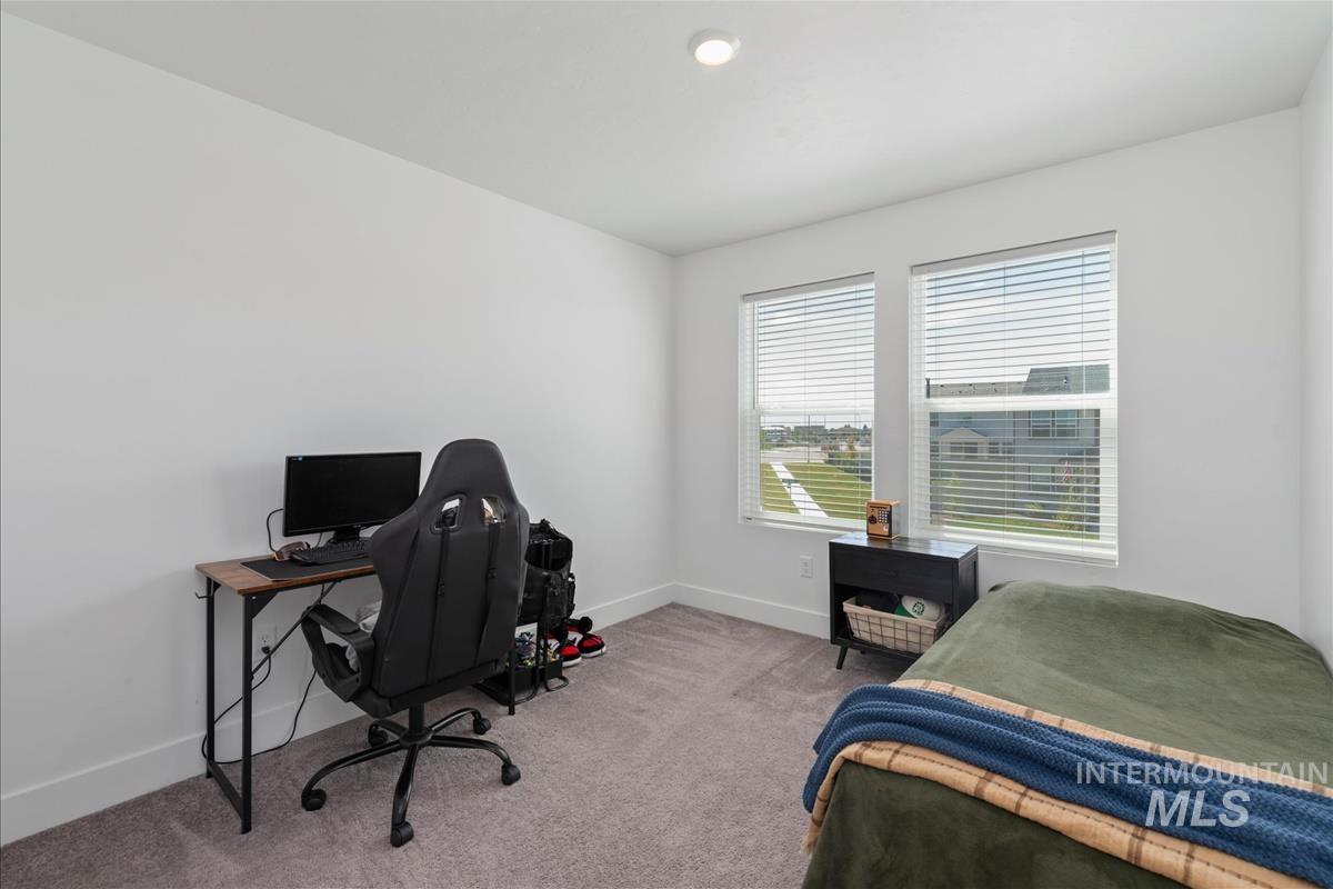 Bright room featuring two windows with blinds, recessed ceiling lighting, and neutral carpet flooring