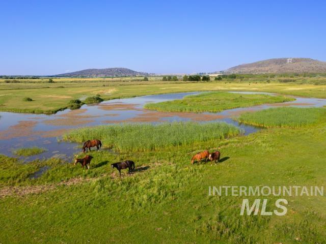 View of mountain backdrop featuring a large body of water and rural landscape