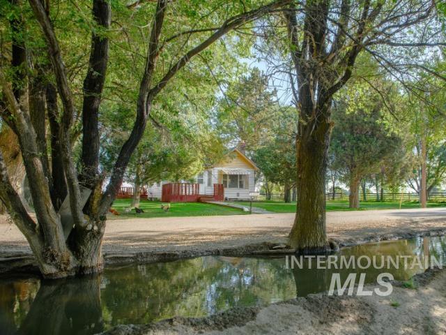 View of community featuring a deck with water view and a lawn