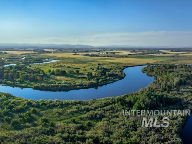 Aerial view of a nearby body of water and a heavily wooded area