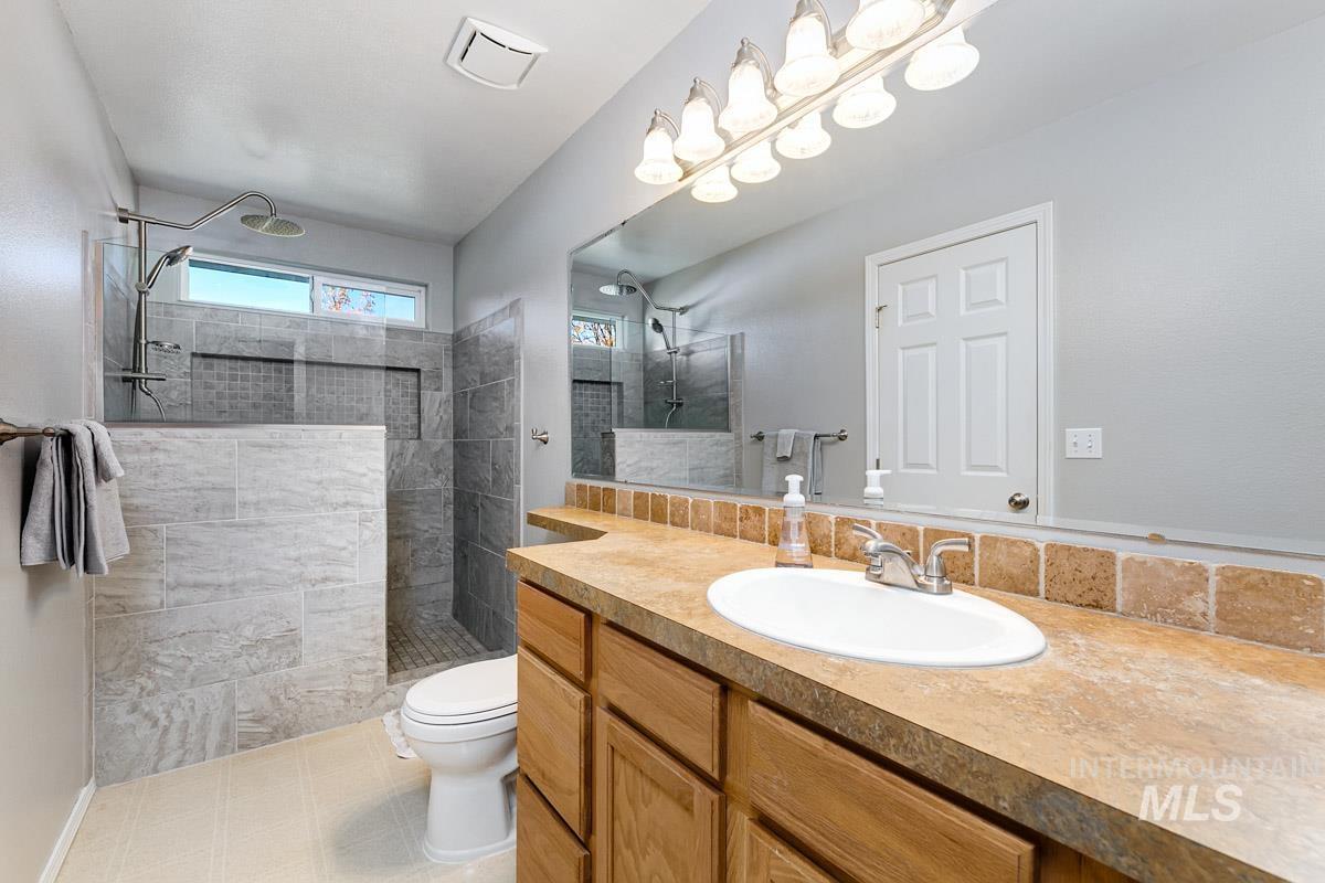 Full bath featuring walk in shower and vanity