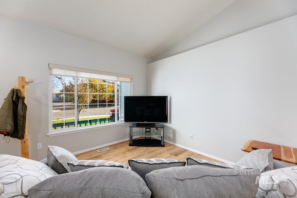 Living area with light wood-style flooring and lofted ceiling