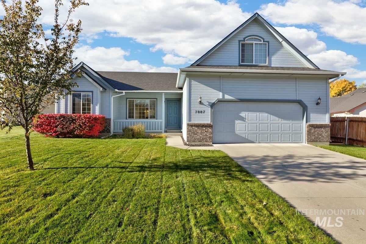 View of front of house with concrete driveway, brick siding, and a garage