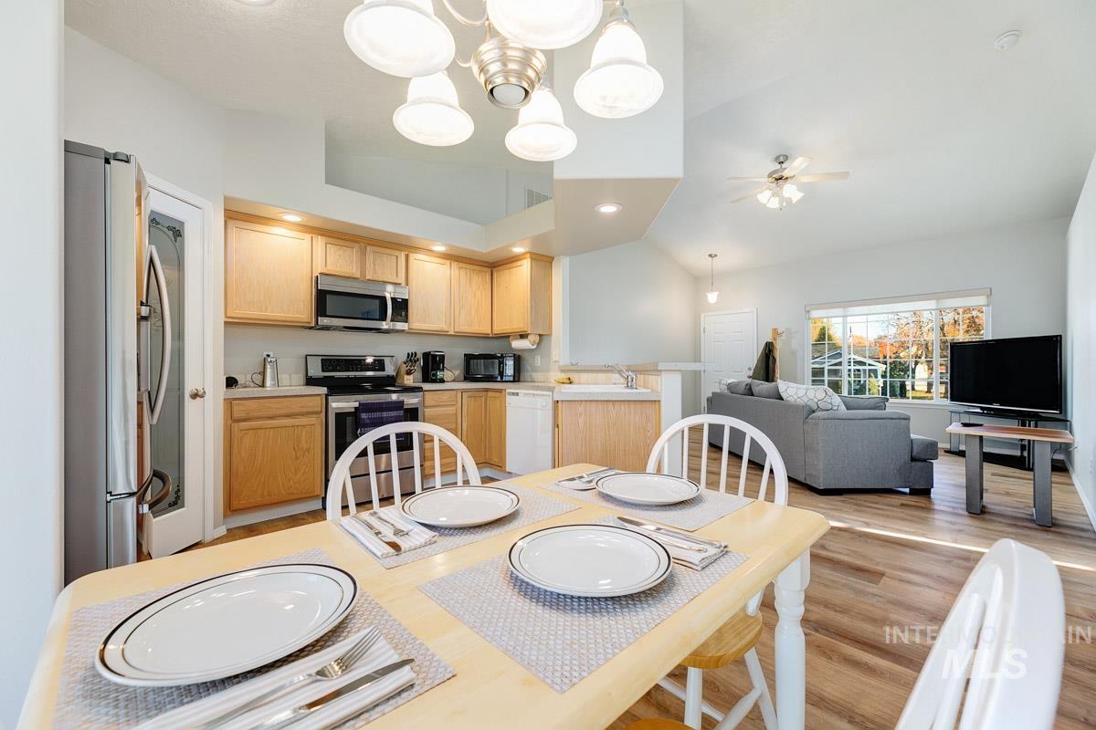 Dining room with light wood-style flooring, ceiling fan, a chandelier, and recessed lighting
