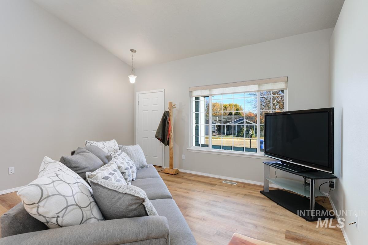 Living area with lofted ceiling and light wood-style flooring