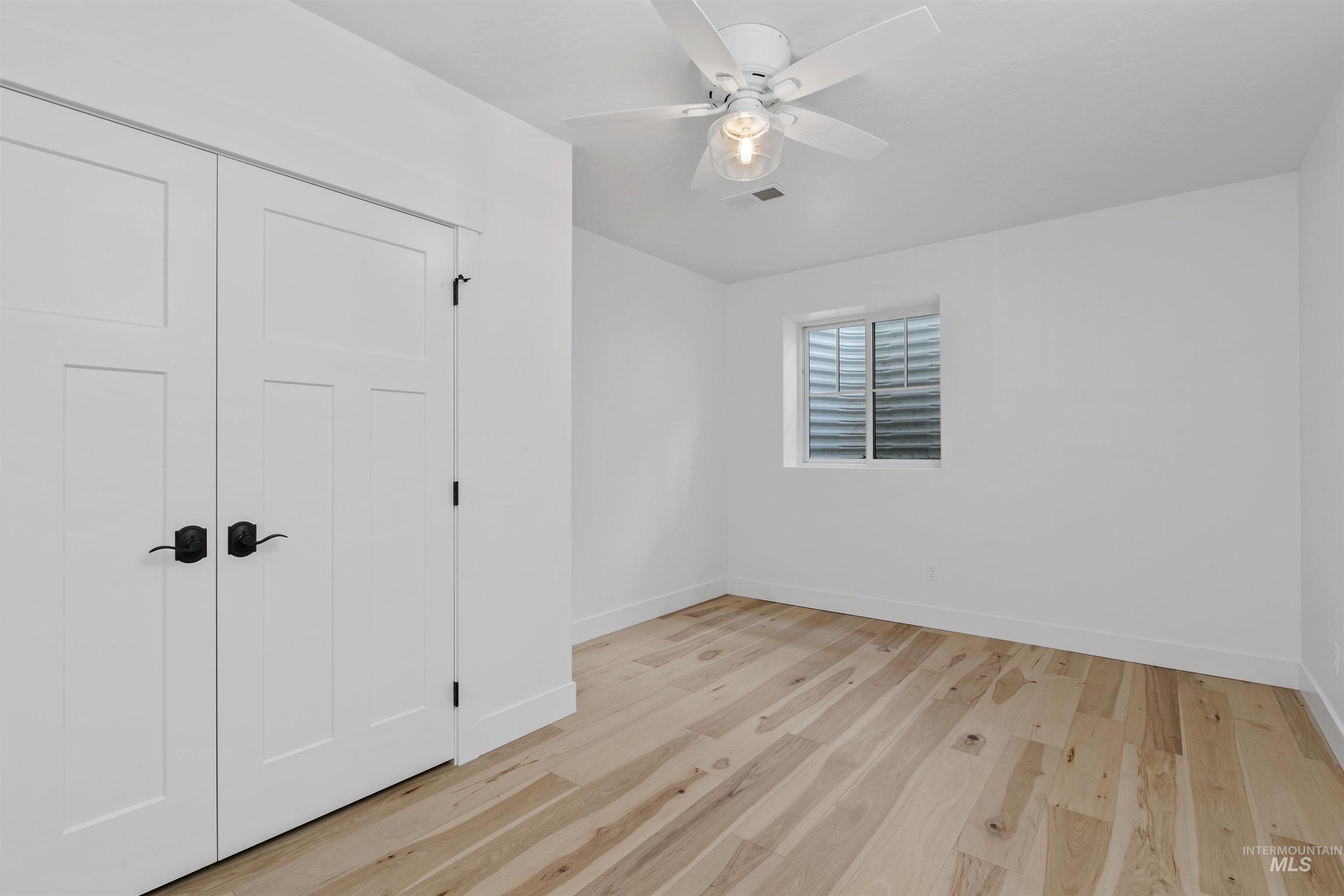 Unfurnished bedroom featuring light wood-style flooring, a closet, and ceiling fan