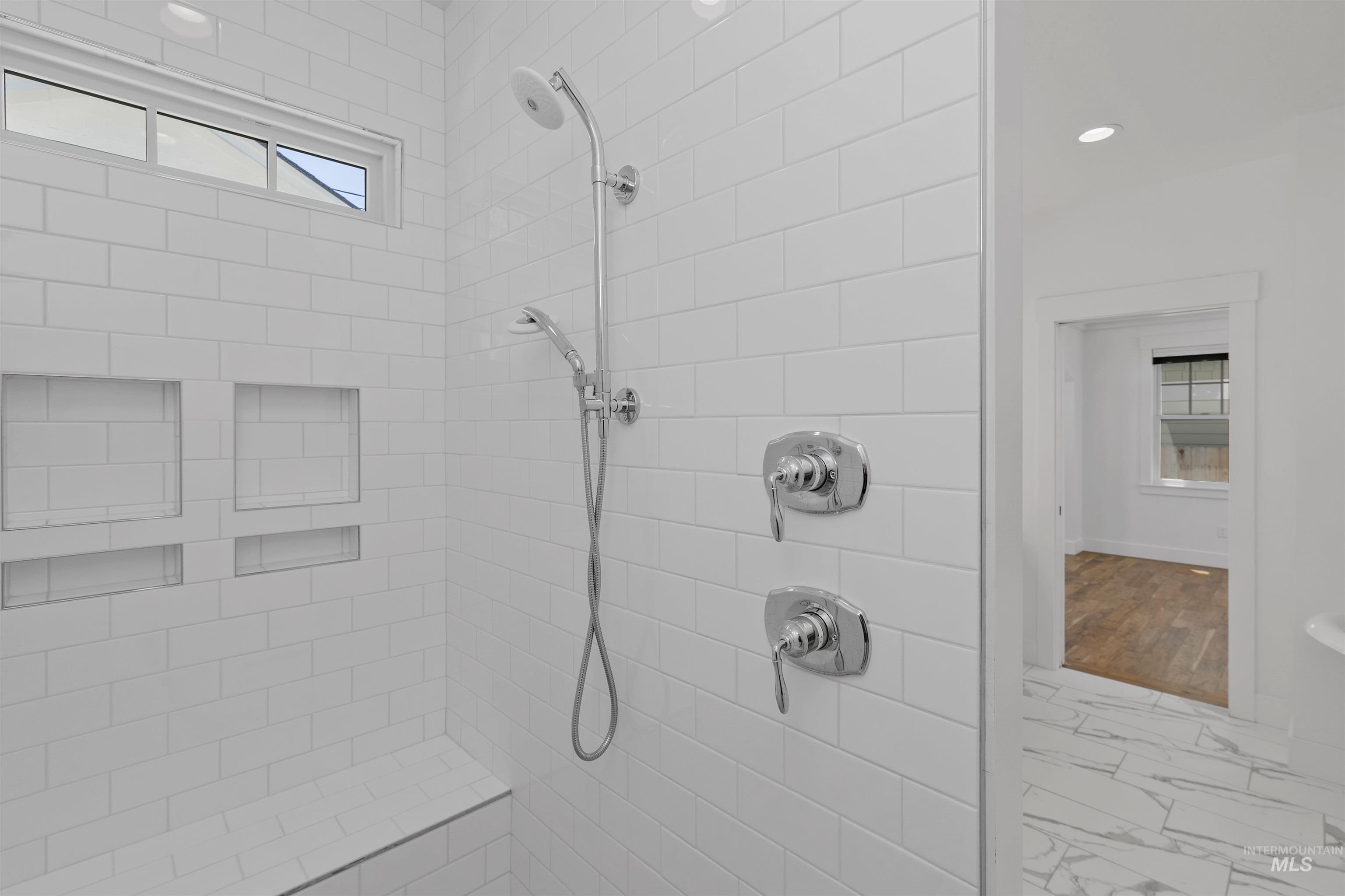 Full bathroom with a tile shower, marble look tiles, and recessed lighting
