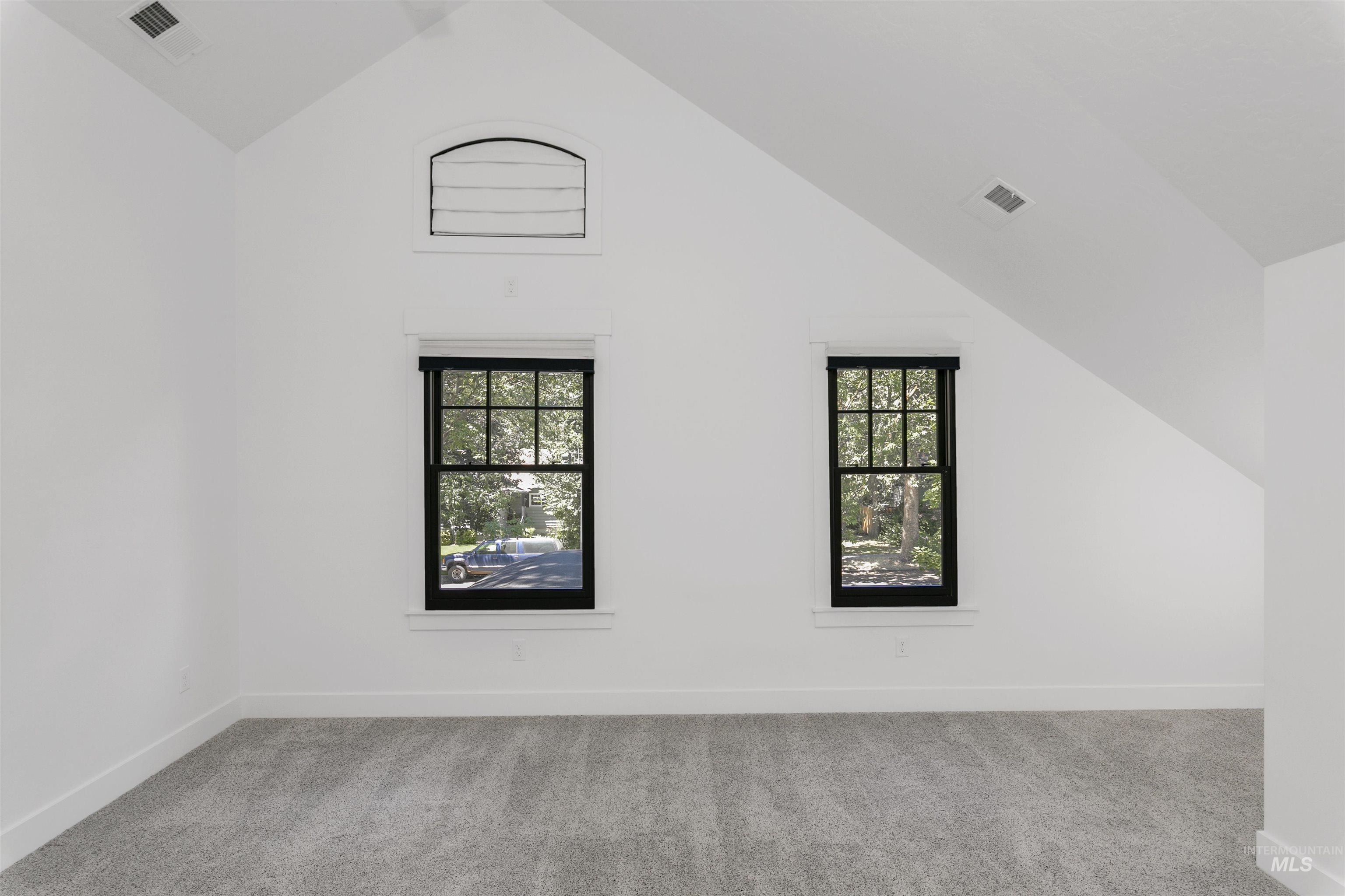 Bonus room with vaulted ceiling and carpet