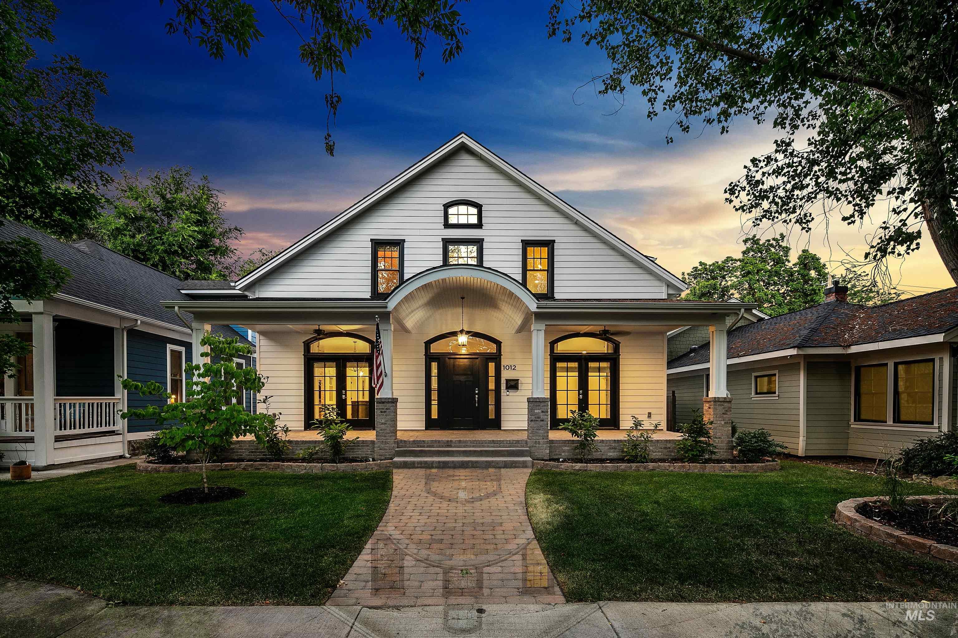 View of front of home with covered porch, a front lawn, and french doors