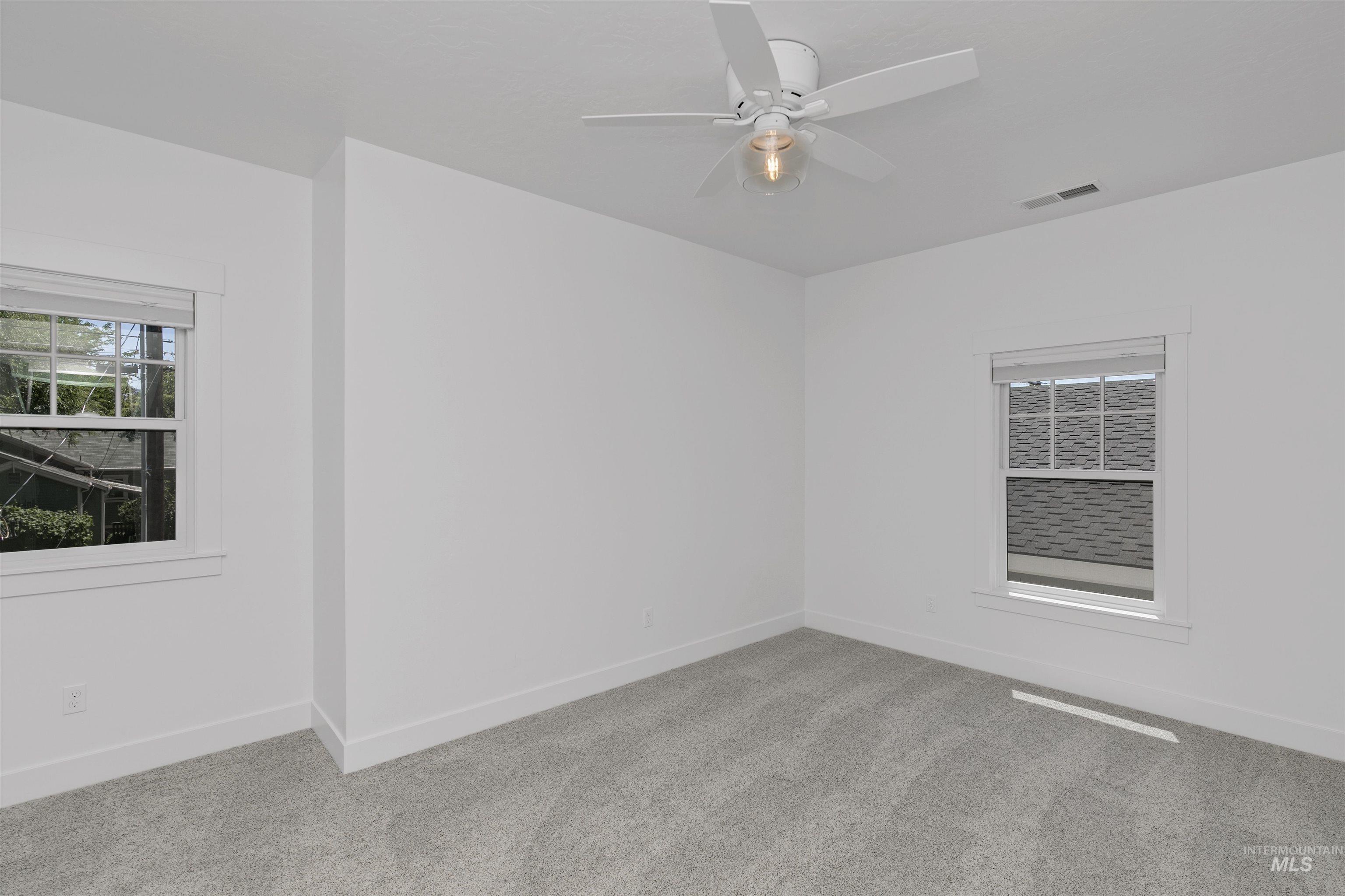 Spare room with carpet flooring and ceiling fan