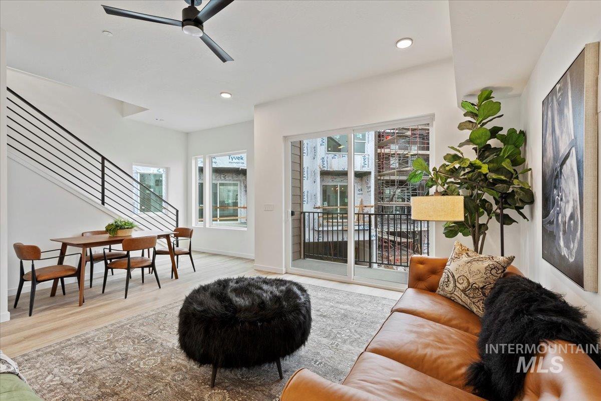 Living area featuring stairway, ceiling fan, wood finished floors, and recessed lighting