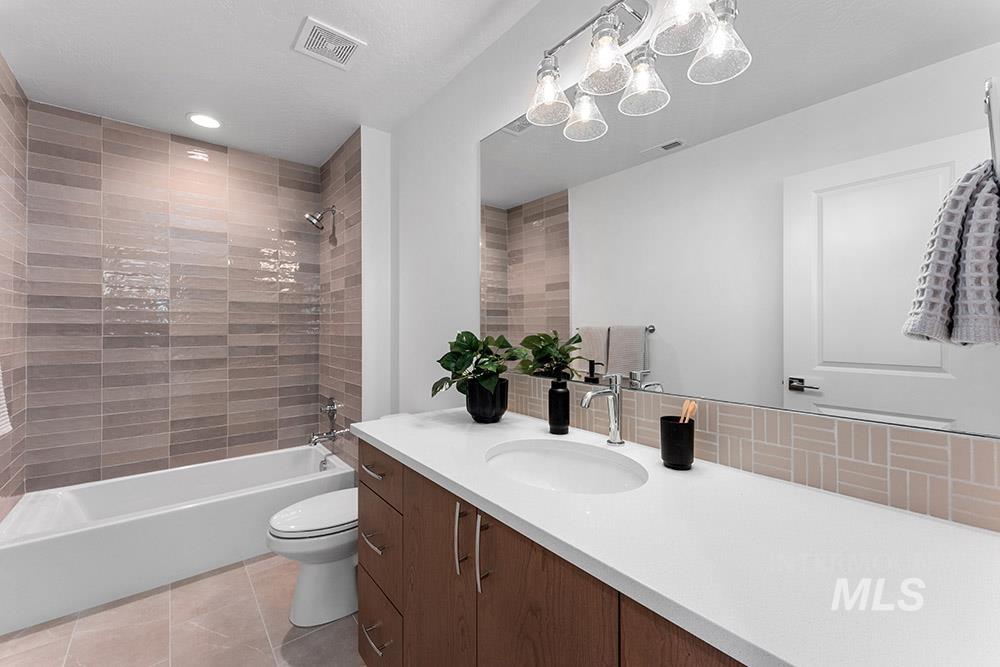 Full bath with vanity, tub / shower combination, tile patterned floors, recessed lighting, and backsplash