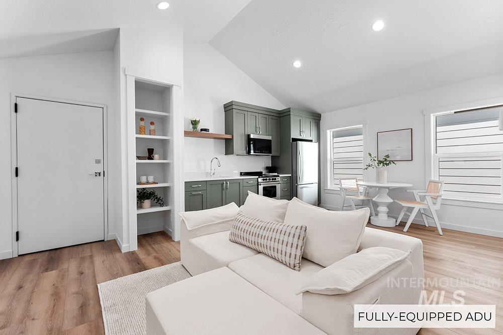 Living room featuring light wood-type flooring, recessed lighting, lofted ceiling, and built in shelves