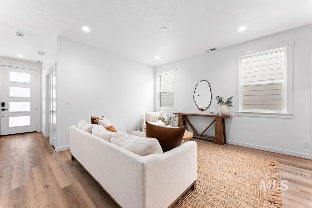 Living area with light wood finished floors and recessed lighting