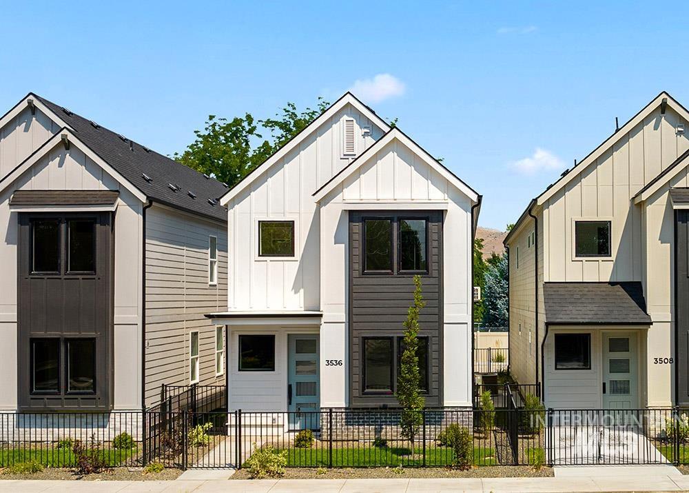 Modern farmhouse style home with board and batten siding and a fenced front yard