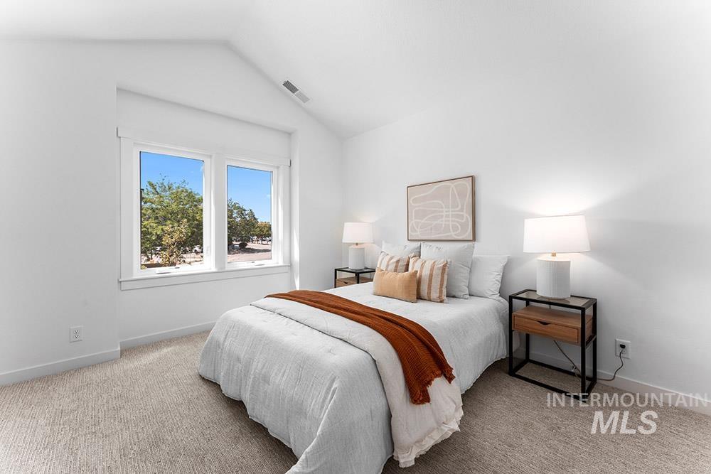 Bedroom featuring vaulted ceiling and carpet floors
