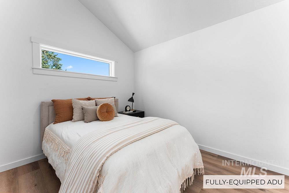 Bedroom with lofted ceiling and wood finished floors