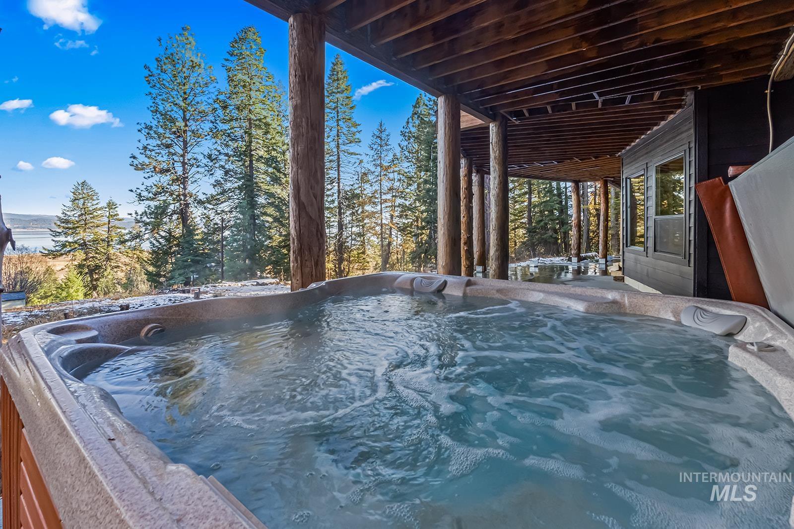 View of swimming pool with a hot tub and patio surround