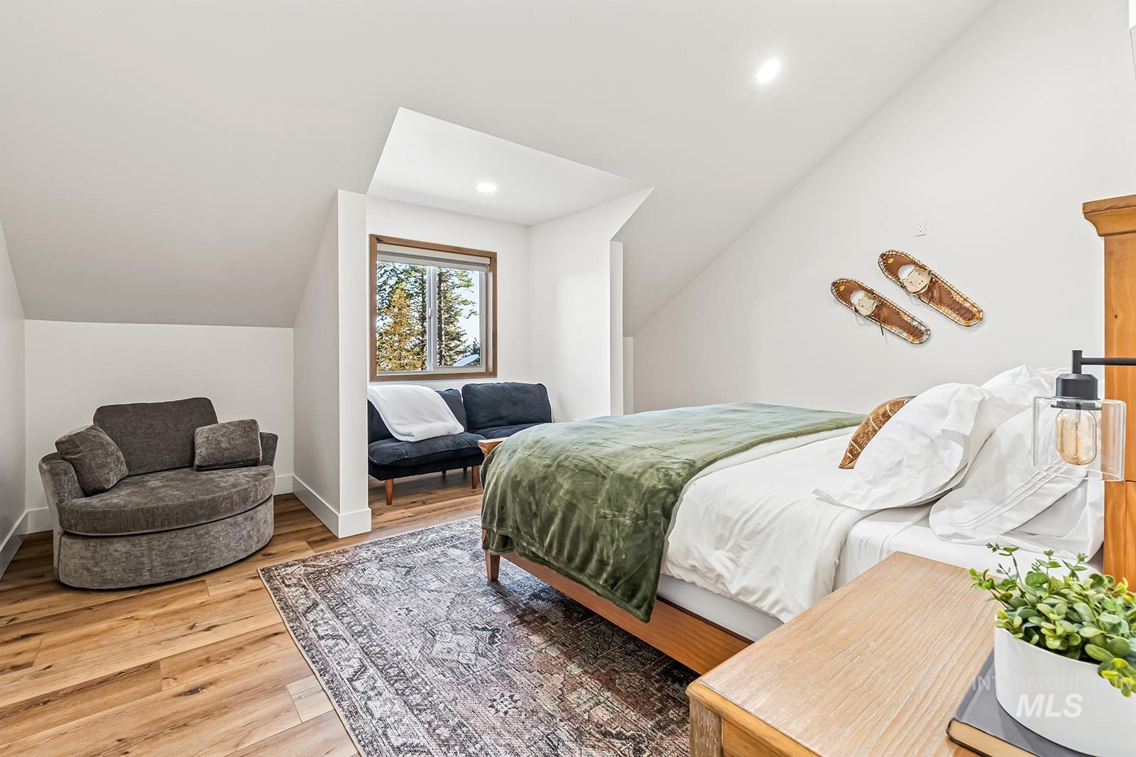 Bedroom featuring wood finished floors, vaulted ceiling, and recessed lighting
