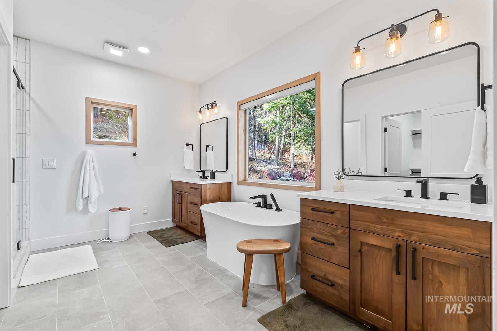 Bathroom with two vanities, a soaking tub, and recessed lighting