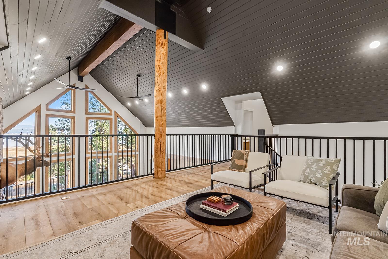Sitting room with a ceiling fan, wood-type flooring, recessed lighting, and a high wooden beamed ceiling