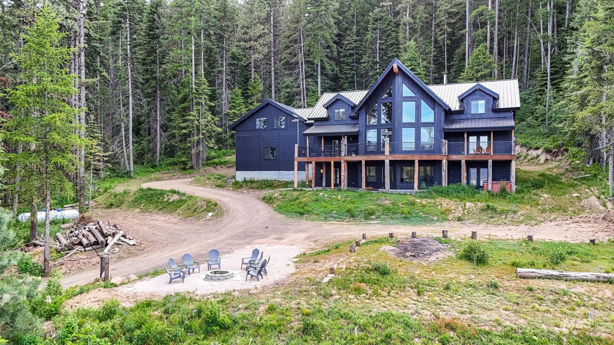 Striking custom-built residence featuring a black exterior with natural wood accents and a metal roof