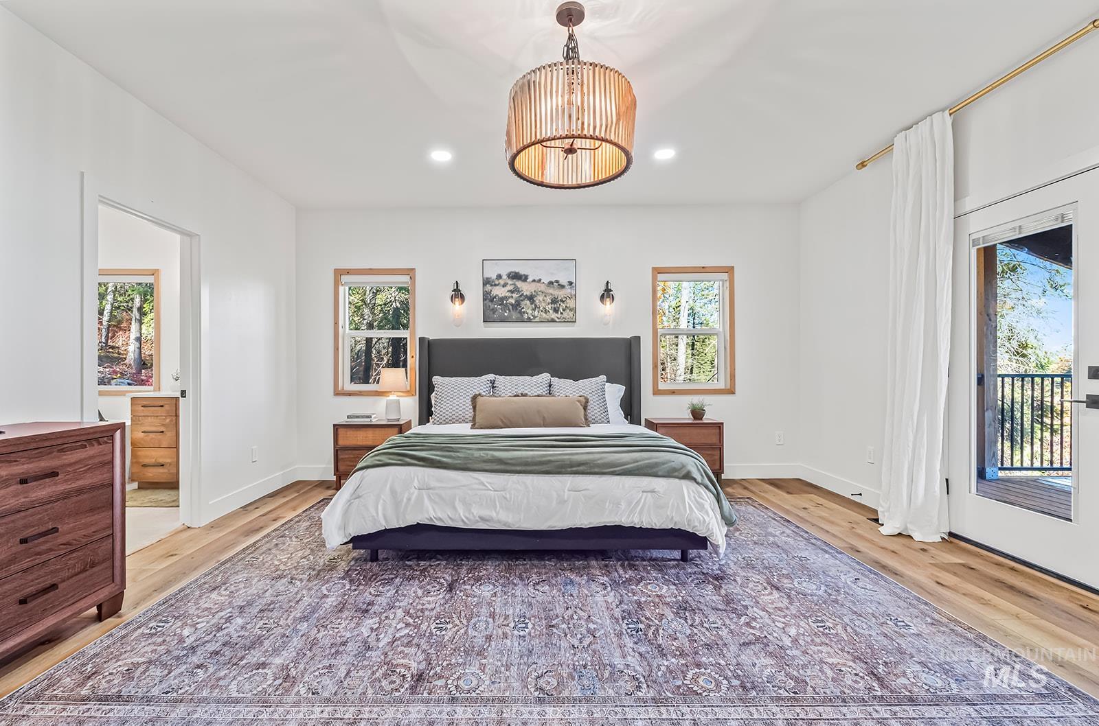 Bedroom with access to outside, multiple windows, a chandelier, and wood finished floors