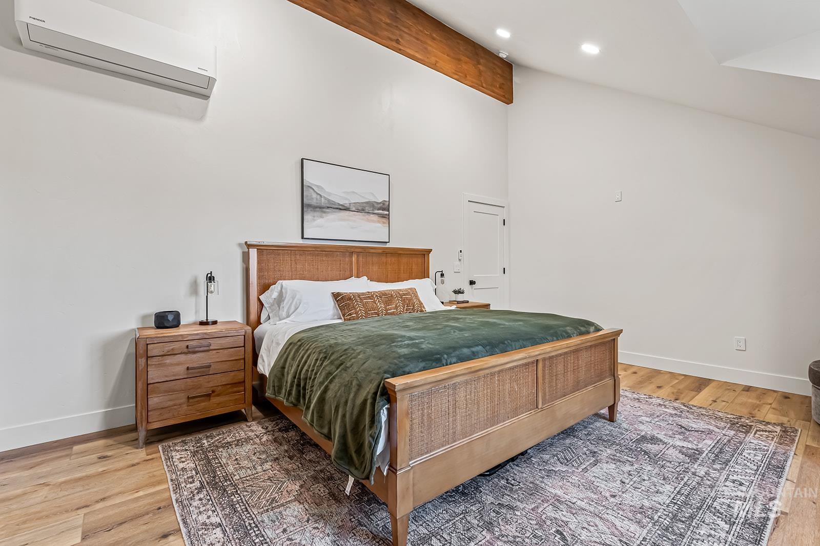 Bedroom with light wood finished floors, lofted ceiling with beams, and recessed lighting