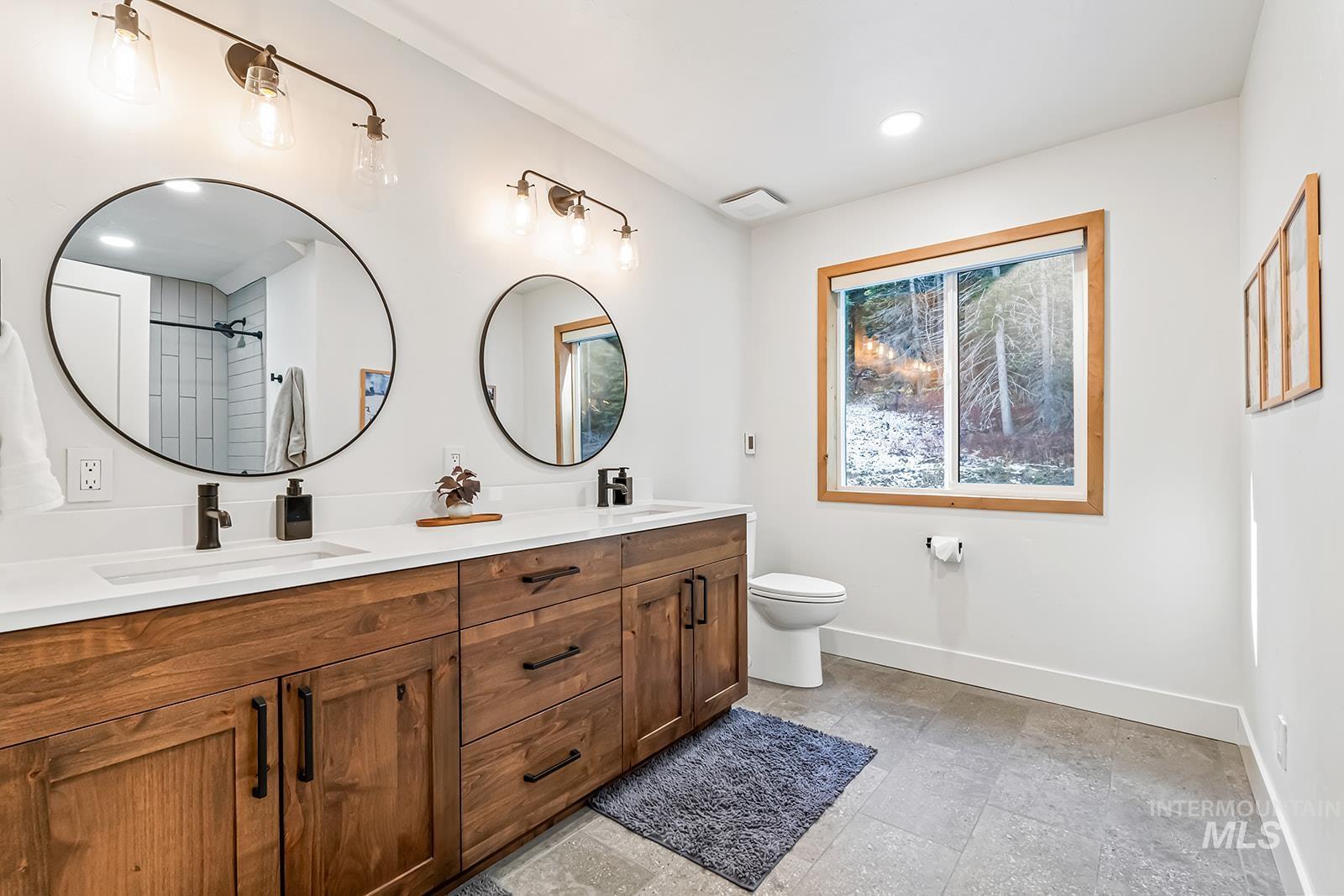 Bathroom with double vanity, a shower, and recessed lighting