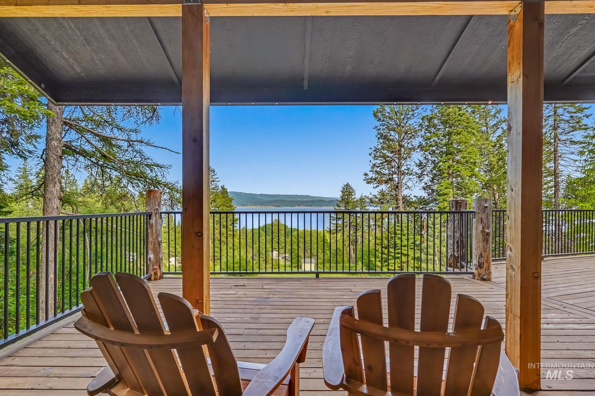 Expansive wood-finish deck with black metal railings, supported by substantial wood posts