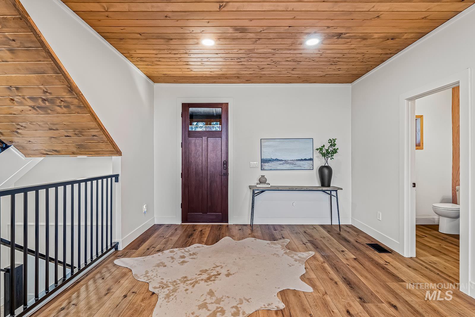 Entryway featuring wooden ceiling, light wood-type flooring, ornamental molding, and recessed lighting