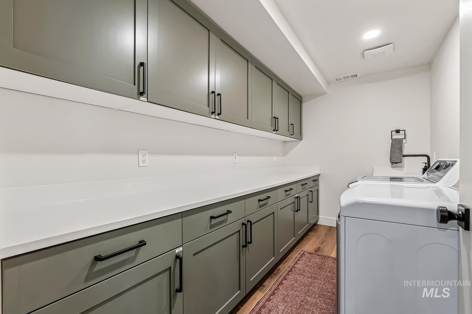 Laundry room featuring washer and dryer, dark wood finished floors, cabinet space, and recessed lighting