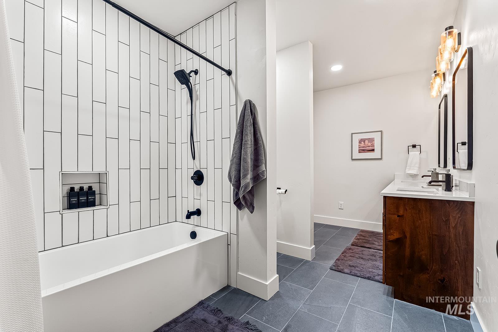 Full bath with vanity, shower / bath combination with curtain, and dark tile patterned floors