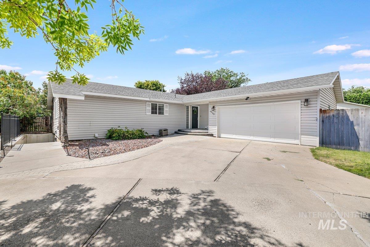 Ranch-style house with an attached garage, driveway, and a shingled roof