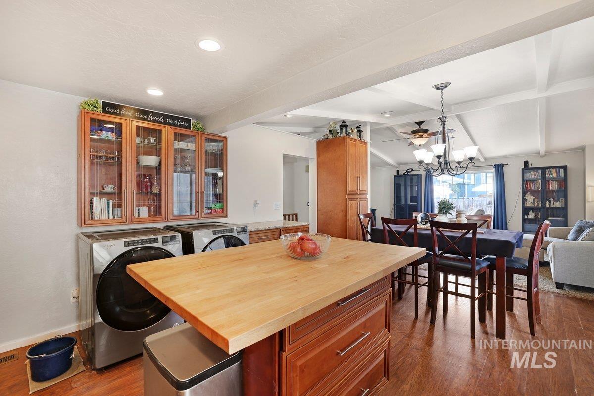 Dining area featuring dark wood-type flooring, washer and dryer, a chandelier, and recessed lighting