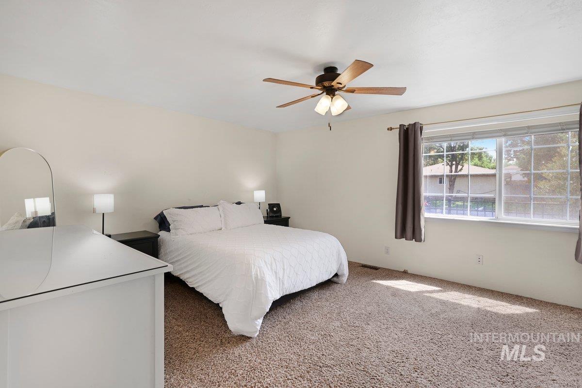 Carpeted bedroom with ceiling fan