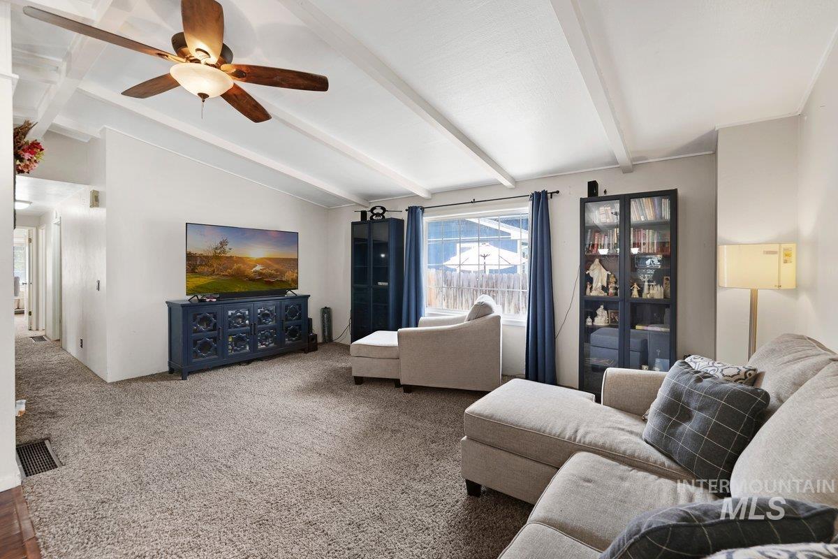 Living area featuring a ceiling fan and carpet flooring