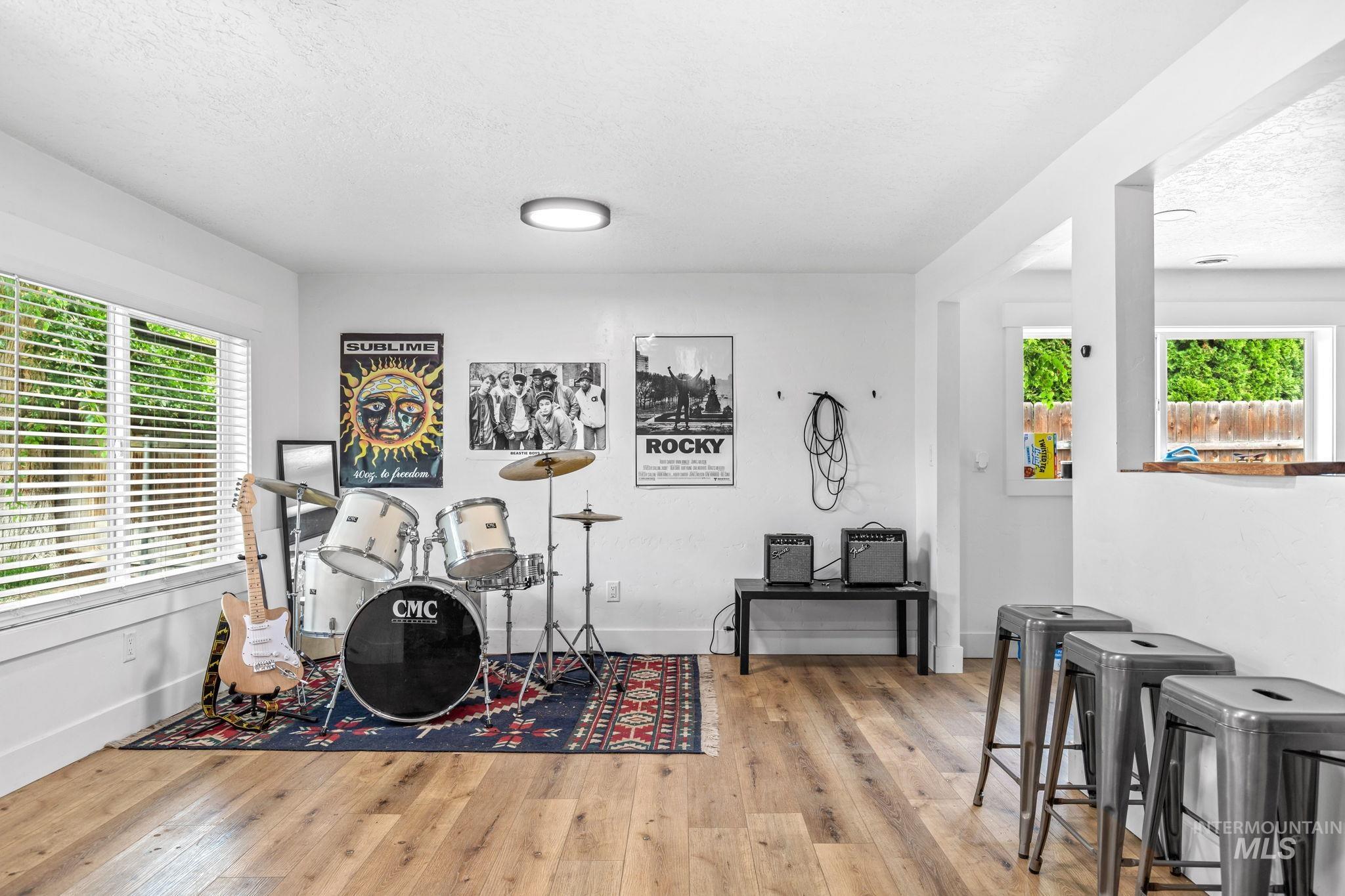 Open concept recreation room featuring wood-finish flooring and ample natural light from multiple windows