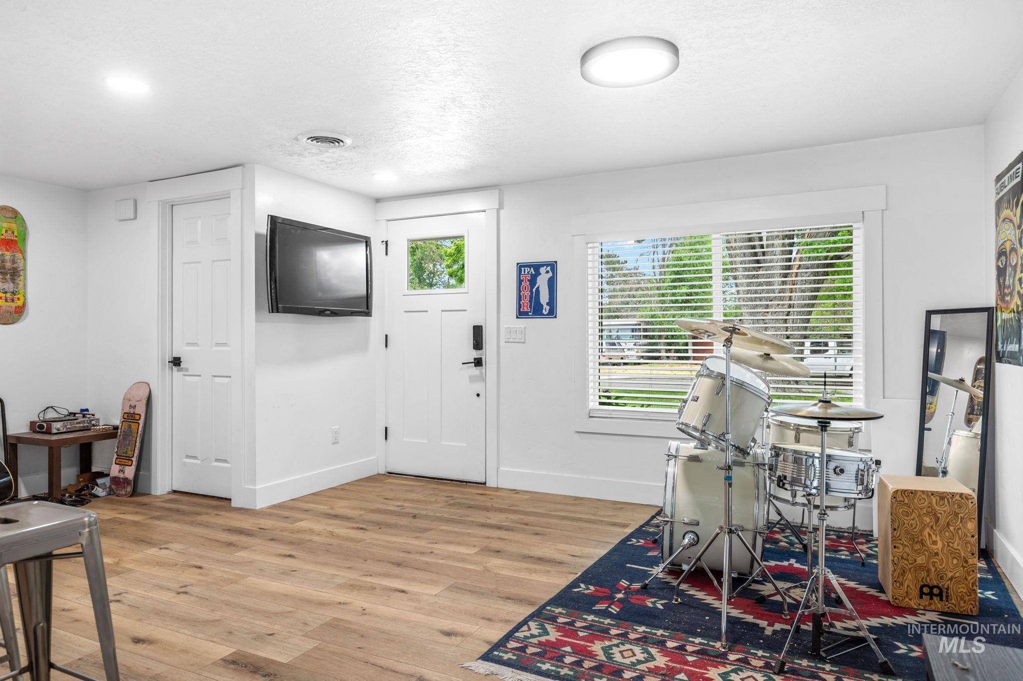 Bright room featuring wood-finish flooring, white trim, and recessed lighting