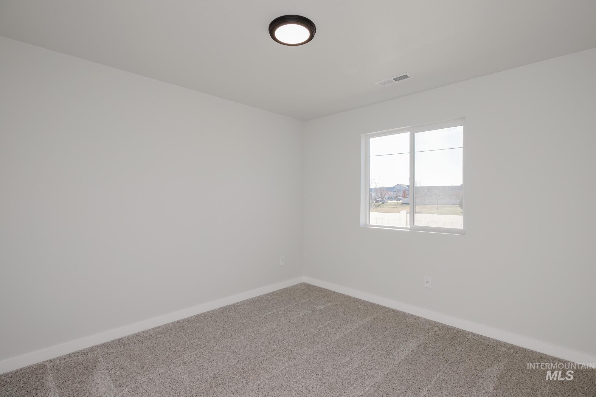 Carpeted spare room with baseboards