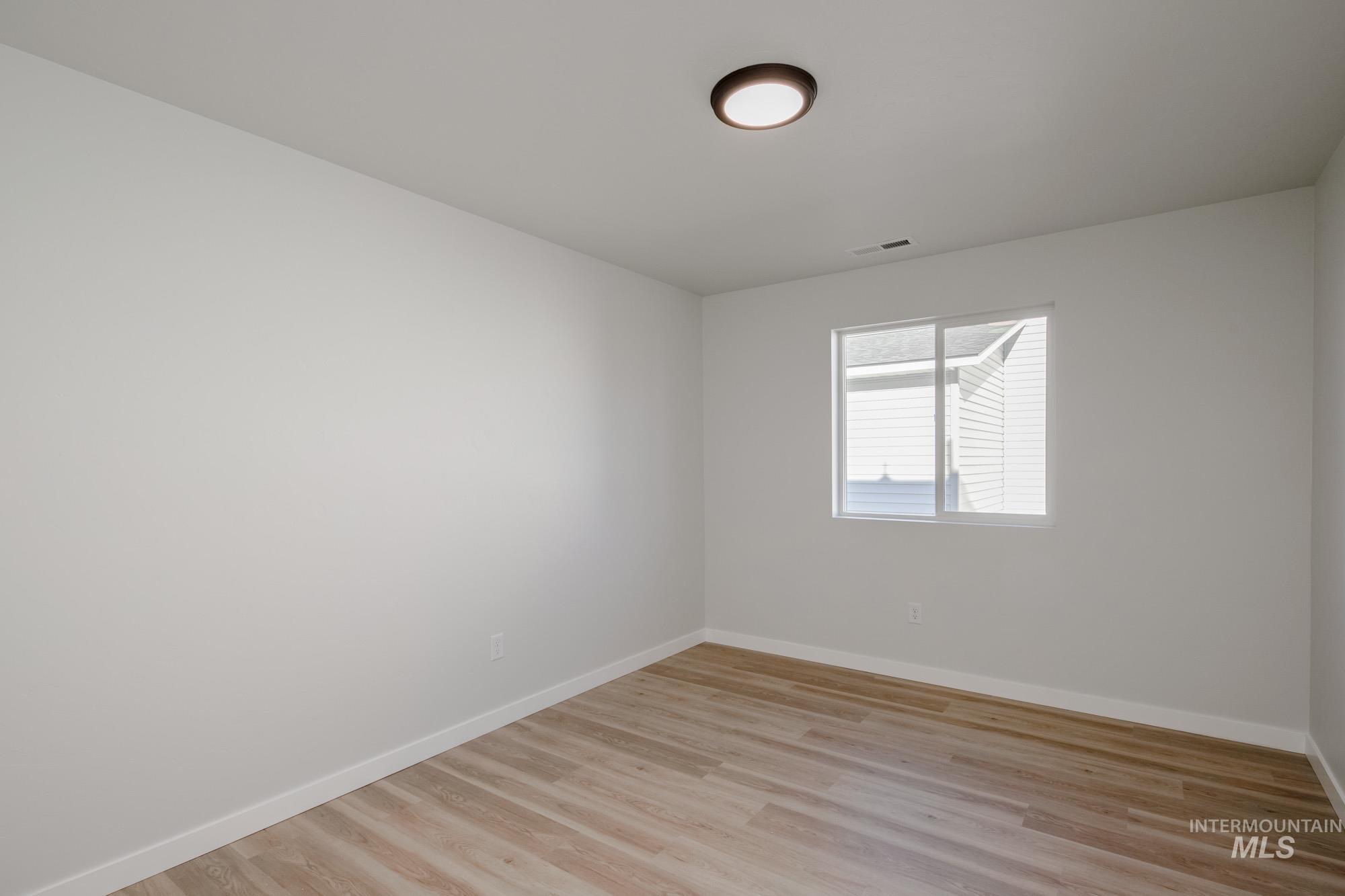 Empty room with baseboards and light wood finished floors