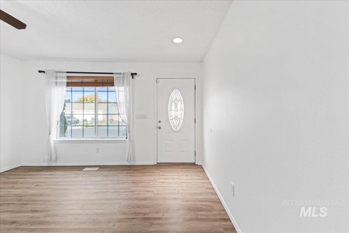 Foyer with light wood-style flooring and recessed lighting
