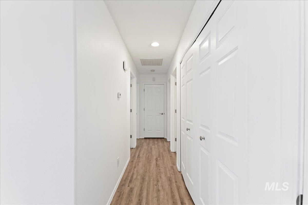 Corridor featuring light wood-style floors and recessed lighting