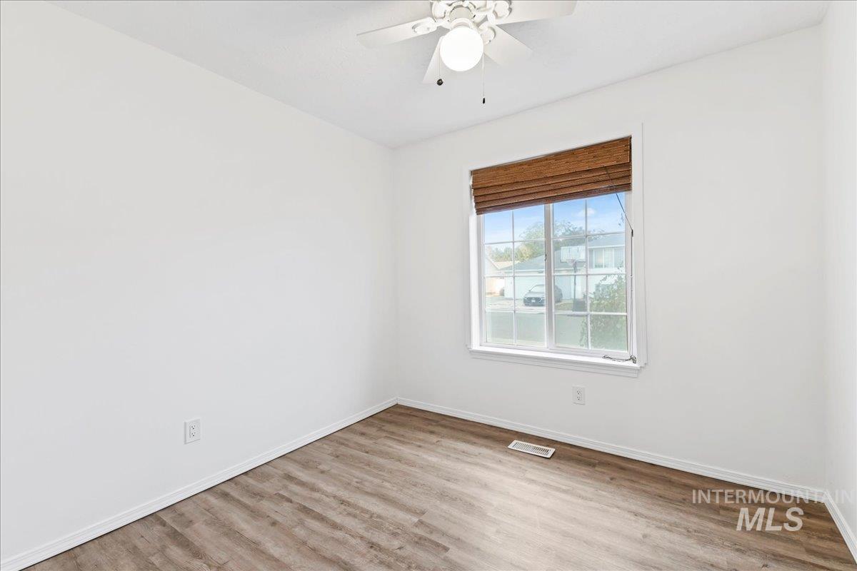 Unfurnished room with light wood finished floors and a ceiling fan
