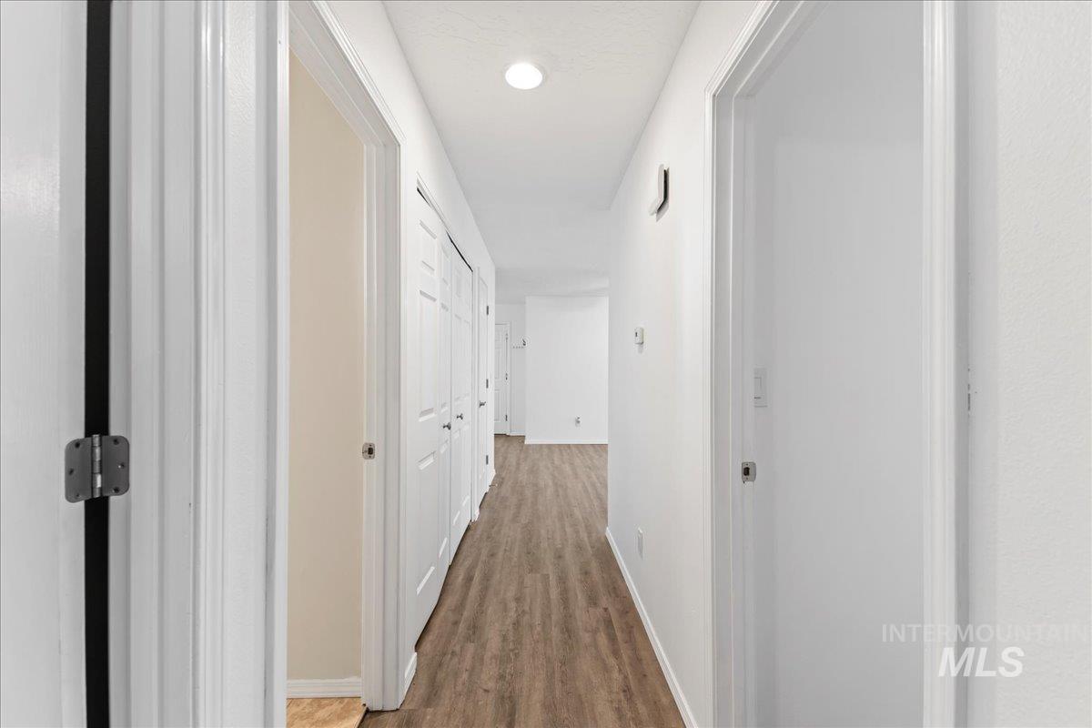 Corridor featuring wood finished floors and recessed lighting