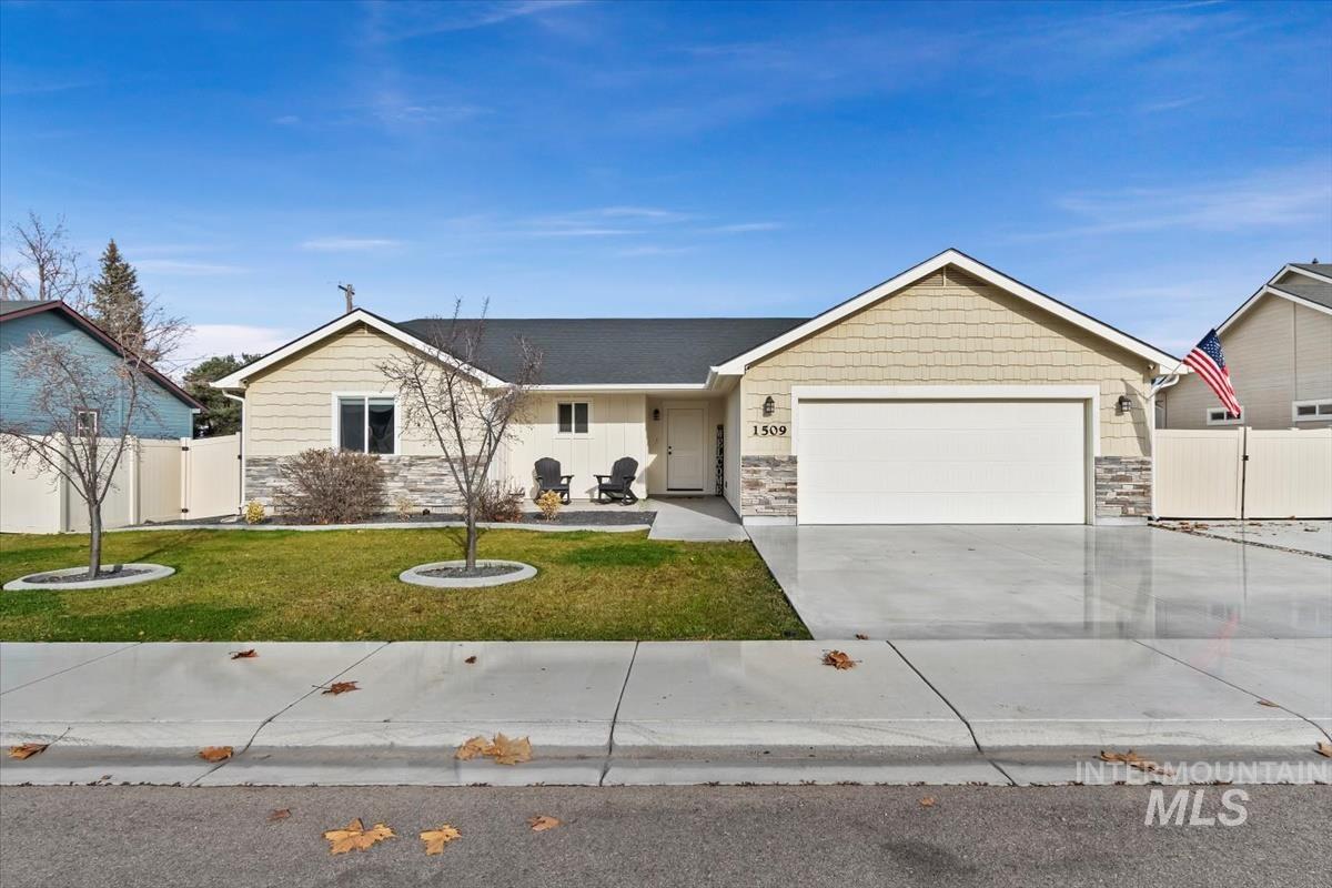 Ranch-style home featuring stone siding, covered porch, a gate, and driveway