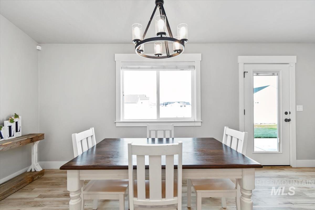 Dining space with plenty of natural light, light wood-style floors, and a chandelier